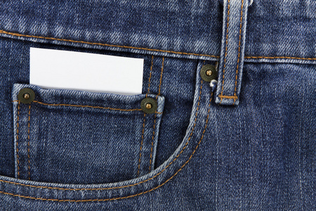 在前面的口袋里的蓝色牛仔裤的白卡纸的一部分