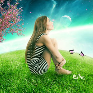 仰望星空女人坐在仰望星空的绿色草地上地球行星上照片