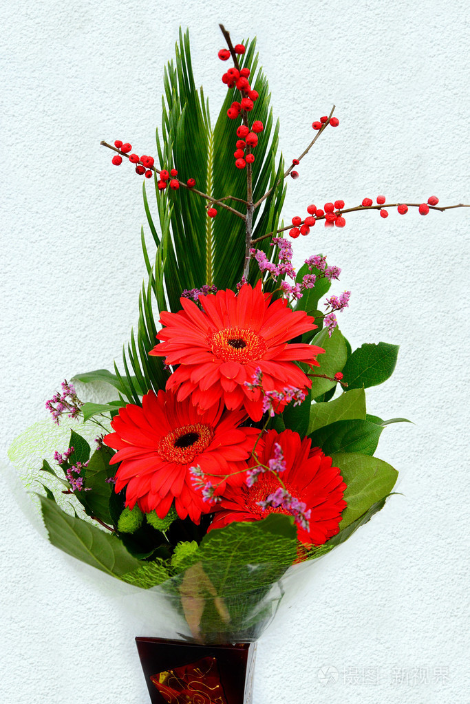 雏菊花红色非洲菊与树叶的花束
