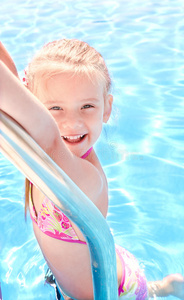 游泳池里微笑的小女孩
