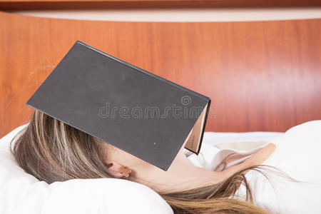 小女孩脸上挂着书睡觉