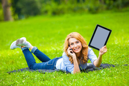 坐在公园里的漂亮女人拿着笔记本电脑