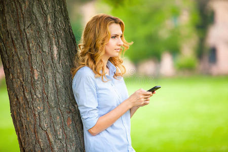 年轻漂亮的女人在用她的手机