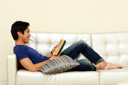 在沙发上休息时看书的男人
