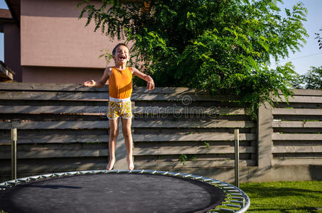 蹦床上的快乐男孩照片
