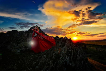 落日余晖中披着红斗篷的美女