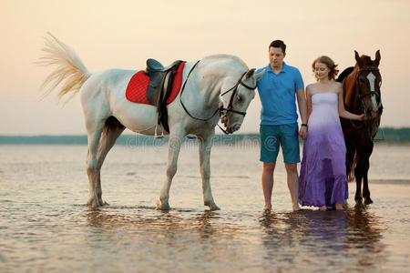 情侣骑马.一个年轻的男人和一个漂亮的女人在海上.只读存储器照片