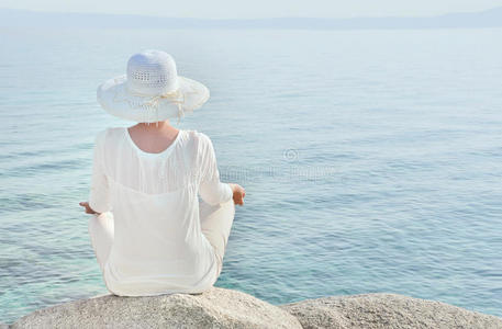 戴着帽子的女人面朝大海沉思