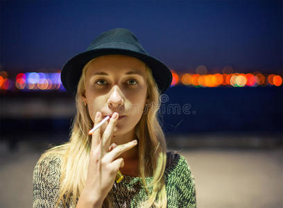 分散烟的小女孩戴帽子的小女孩在街上抽烟照片