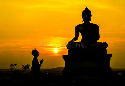 拜佛人们拜佛,夕阳天空背景上的佛像照片