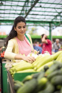 在市场上买蔬菜的年轻女人