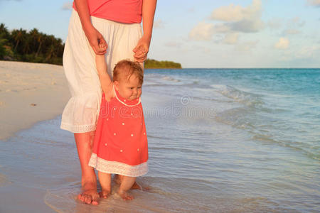 母亲和小女儿在海滩上散步