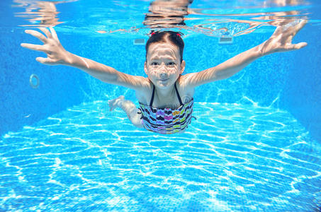 快乐活泼的水下孩子在游泳池里游泳
