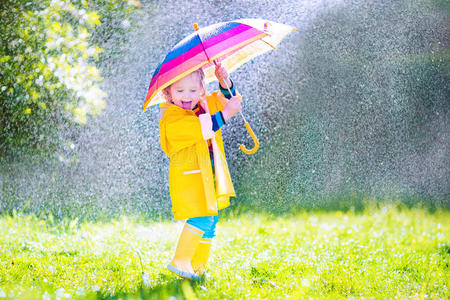 有趣的小孩在雨中打伞