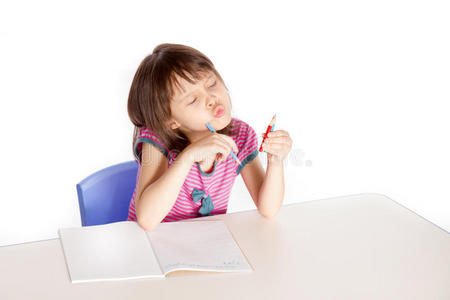 女孩在做作业，看着她的铅笔