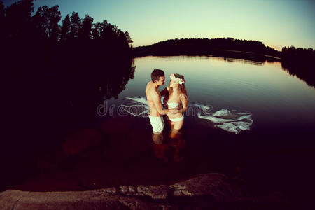 晚上在湖里的两个情人。夕阳下湖中的女孩和男人。