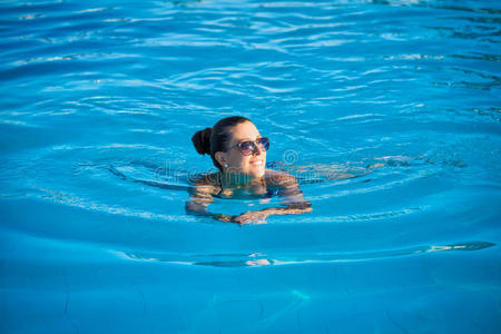 在蓝色游泳池附近放松的女人