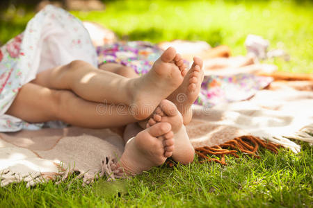 两个女孩的脚躺在草地上玩耍的照片照片