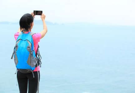 年轻女子的徒步旅行者拍照