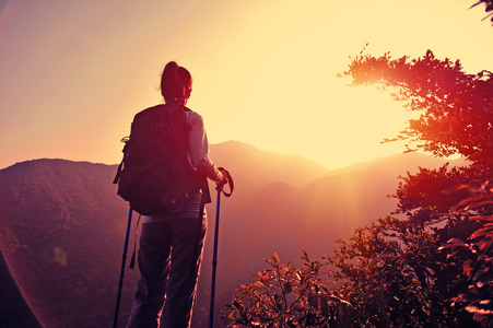 女人的徒步旅行者在山顶欣赏