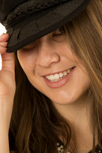 女人窥视开玩笑地戴了一顶黑色帽子的特写镜头