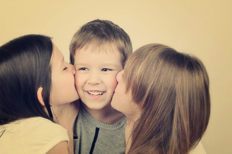 彩色的图像两个十几岁女孩亲吻小爱笑的男孩