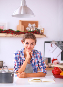 微笑在厨房里的年轻女子，孤立的圣诞节背景