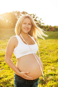 卷尺的怀孕女人的画像