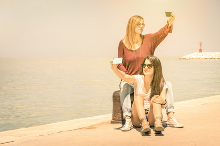 时髦女友采取双自拍照在码头码头友谊和乐趣的新趋势和技术的概念最好的朋友用现代智能手机固定时刻