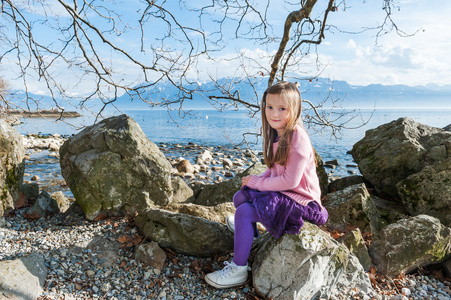 可爱的小女孩，在一个好的春日湖旁边休息