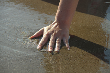女人触摸海水的手
