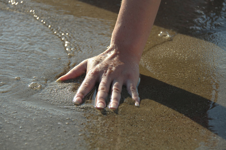 女人触摸海水的手