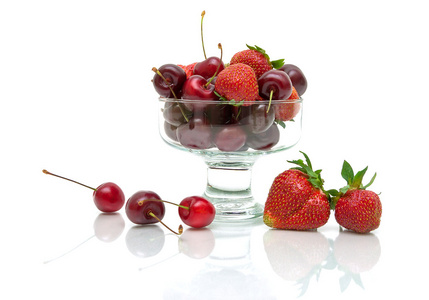 多汁的樱桃和草莓在玻璃碗上孤立的 whi