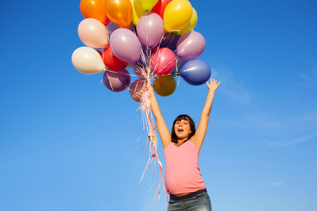 在户外用气球美丽快乐年轻孕妇女孩