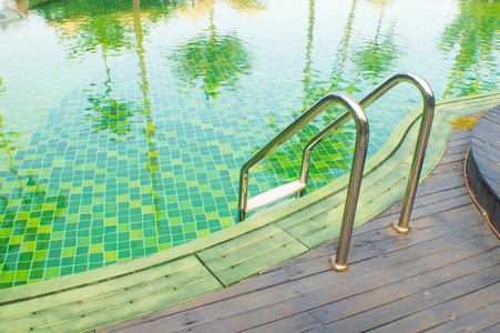 带柚木地板的绿色游泳池