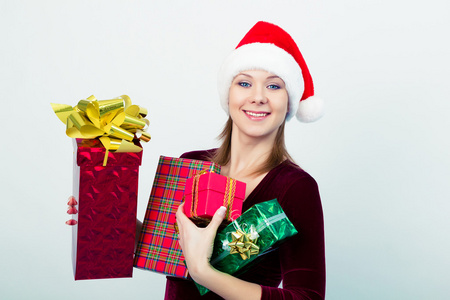 快乐的女孩，在圣诞老人的帽子与礼品盒