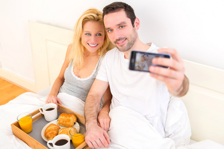 在早餐的吸引力对年轻夫妇以自拍照