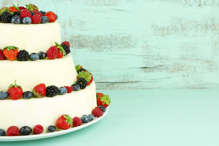 浆果色木背景上的美丽婚礼蛋糕。