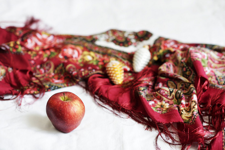 在白色的背景和一条红色的围巾上的红苹果