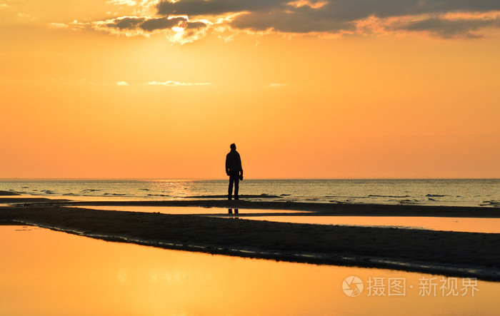 一个人在海边看日落的轮廓