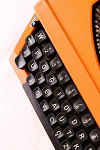 白色背景上的橙色老式打字机