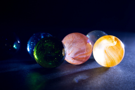 在黑色背景下的彩色半透明玻璃光泽球照片