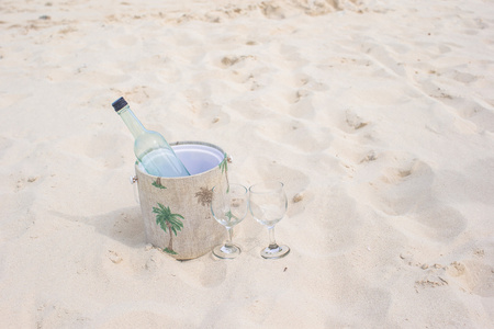 瓶酒和两个眼镜在沙滩上