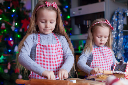 小女孩在烘烤圣诞姜饼的连指手套