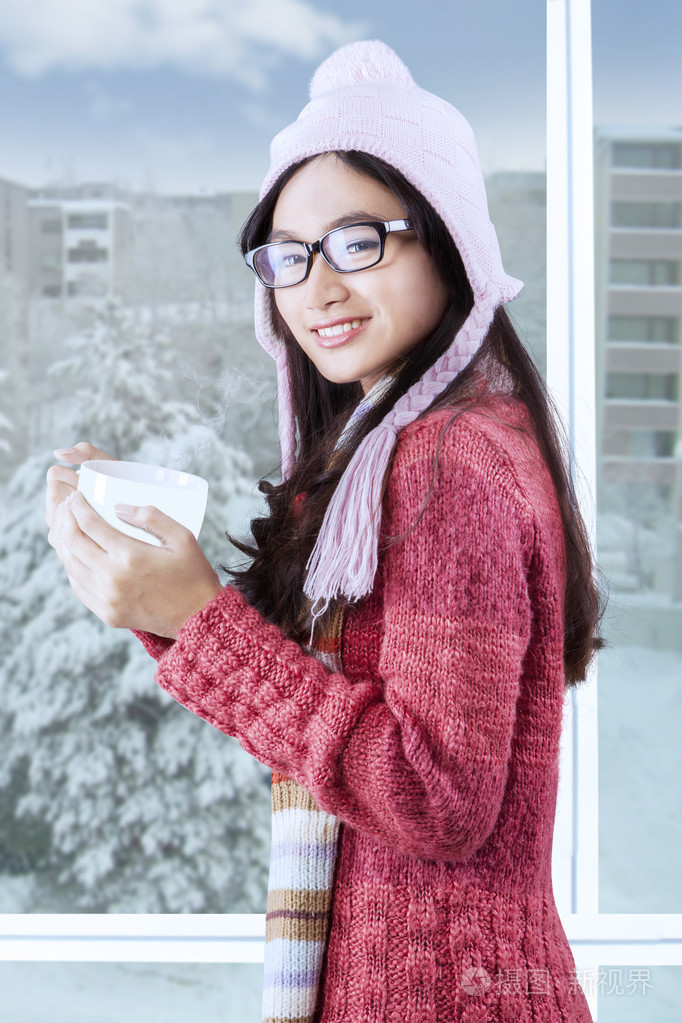 美丽的小女孩微笑着与冬天的衣服