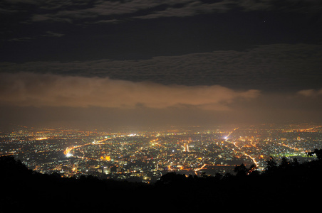 查看在晚上用灯和城市泰国为背景