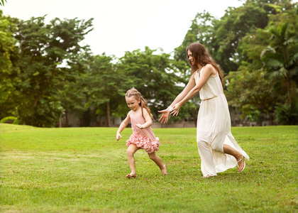 母亲和女儿在公园中爱手牵手散步