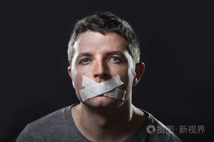 年轻英俊男子嘴上胶带密封以防止他说话