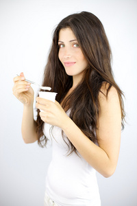 黑发的女孩吃白色酸奶