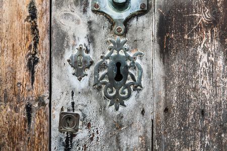 在老的灰色和棕色的旧木头钥匙孔